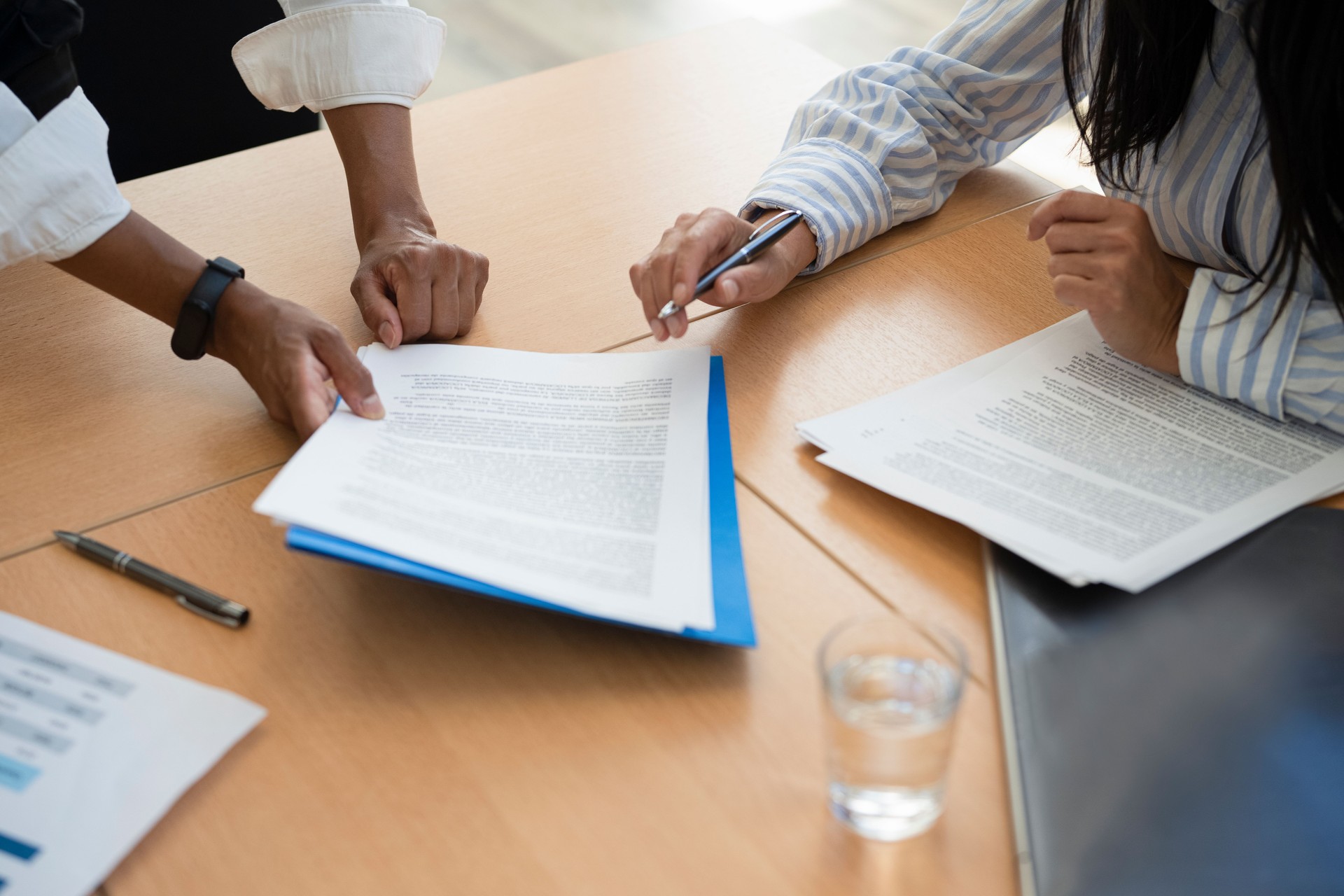 Shot of documents and female hands signing contract